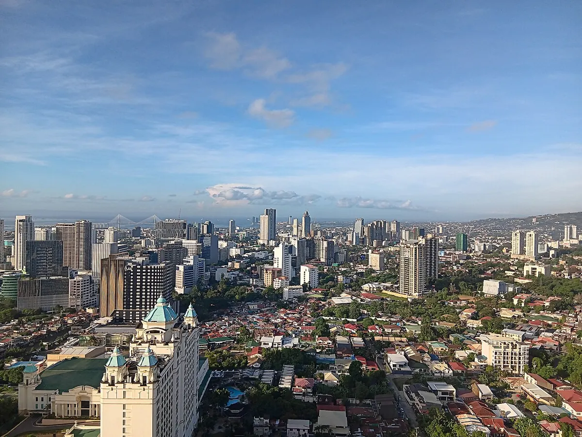 Cebu City skyline with high-rise towers seen from the hills at dusk