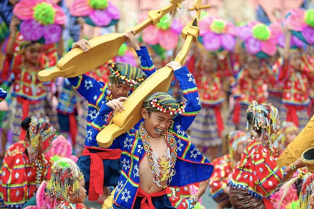 Kadayawan Festival street dancers in colourful tribal costumes performing on a Davao City street