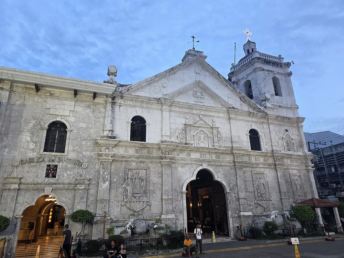 Facade of the Basilica Minore del Santo Niño in Cebu City with devotees gathered in the plaza